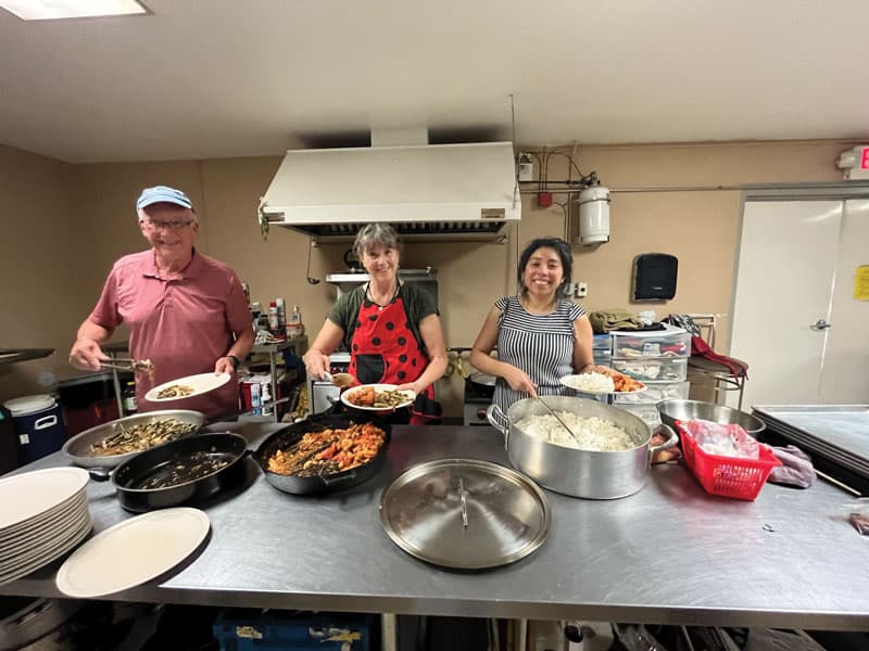 El diácono Bill Toller, Jeannine Clark y Guadalupe Jiménez preparan comida para los migrantes mientras visitan un albergue durante un viaje de inmersión Maryknoll a El Paso, Texas. (Andrea Moreno-Diaz/EE.UU.)