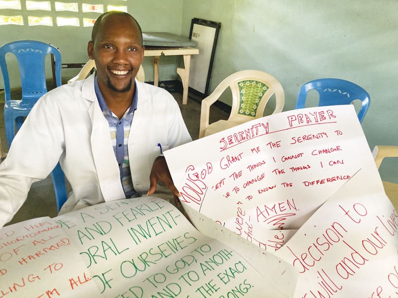 El psicólogo Titus Ngugi, quien invitó a Megan Hamilton a Port Reitz, ayuda a los pacientes a<br />
crear carteles a partir de lecturas de AA para colgar en las paredes de las instalaciones. (Cortesía de Megan Hamilton/Kenia)