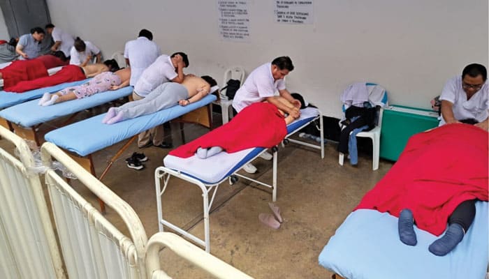 Estudiantes ciegos practican las técnicas de terapia de masaje que aprendieron en el Centro Bartimeo del Sur en reclusas de una cárcel para mujeres en Lima, Perú. (Cortesía de Kyungsu Son, M.M./Perú)