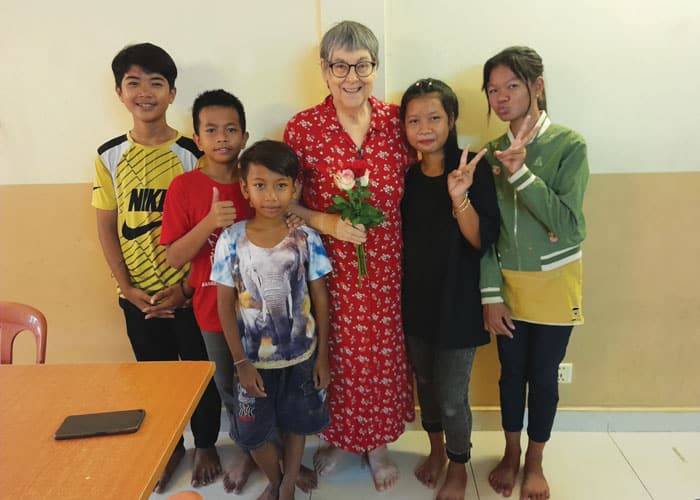 La Hermana Maryknoll Ann Sherman comparte un momento cándido con sus estudiantes camboyanos. La Hermana enseñó inglés a niños empobrecidos en la aldea de Boeng Tumpun. (Cortesía de Ann Sherman, M.M./Camboya)