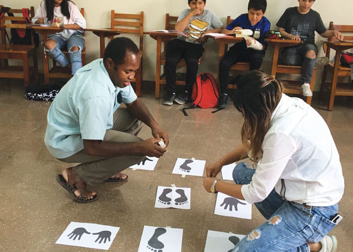 El seminarista Maryknoll Yohana Maswizilo y una catequista preparan una dinámica para la clase de Primera Comunión en la parroquia Santa Ana de Cala Cala en la ciudad de Cochabamba. (Deirdre Cornell/Bolivia)