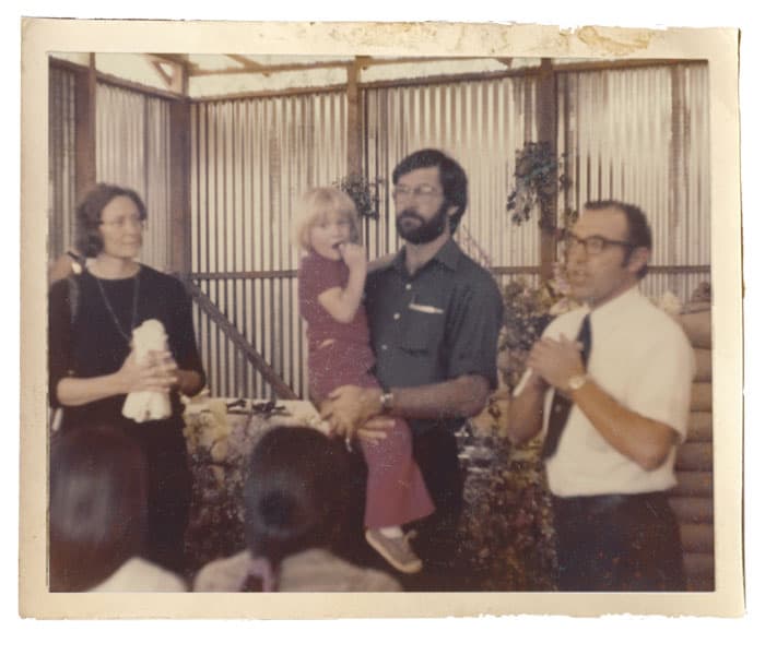Phyllis Gauker observa mientras un sacerdote misionero canadiense sostiene a Johnny. Junto a ellos el Hermano Maryknoll Robert Butsch se dirige a los trabajadores de la construcción que asisten a la Misa conmemorativa para John en la Ciudad de Guatemala. (Cortesía de Phyllis Gauker/Guatemala)