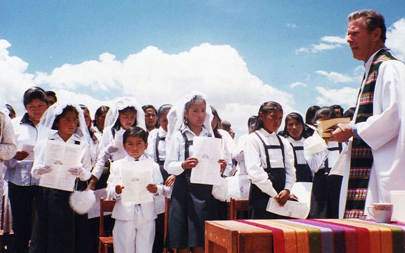 Imagen destacada: El Padre Stephen Judd, entonces director de la Pastoral Universitaria en Puno, Perú, habla a los niños de la escuela San José de Huaraya, durante la celebración de una liturgia al aire libre. (Victor Maqqué/Perú)