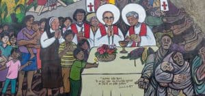Imagen destacada: Un mural en San Salvador retrata a los mártires San Óscar Romero y el padre jesuita Rutilio Grande dando Misa para la gente salvadoreña. Este mural callejero está ubicado afuera del Hospital Divina Providencia, un pequeña residencia para enfermos desahuciados donde el arzobispo Romero sirvió y en donde fue asesinado. (Octavio Durán/El Salvador)