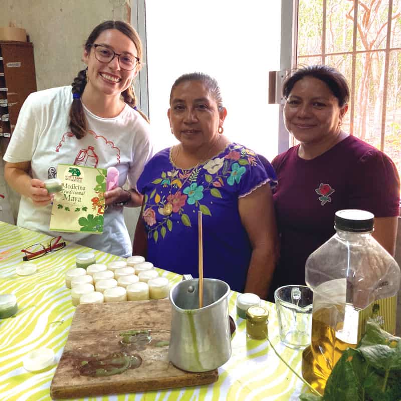W25-trip-merida-3 La participante del viaje de inmersión Maryknoll Brinkley Johnson (izq.) y dos mujeres de la comunidad de Yucatán crean productos mayas tradicionales en la escuela agrícola U Yits Ka’an. (Cortesía de Brinkley Johnson/México)