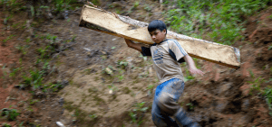Imagen destacada: Un niño carga una tabla de madera destinada para un tunel de minería en Pamintaran, una remota comunidad minera de oro cerca de Maragusan en la isla sureña de las Filipinas, Mindanao, en esta foto de archivo del 6 de junio del 2012. La explotación del trabajo infantil está fundamentada en la pobreza, la desigualdad y la falta de oportunidades que protejan la dignidad humana, escribió el Papa Francisco en un mensaje dirigido a una conferencia mundial en contra del trabajo infantil el 17 de mayo del 2022. (CNS photo/Paul Jeffrey)