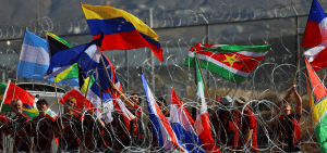 Featured Image: Personas en Ciudad Juárez, México, ondean banderas durante una misa binacional celebrada el 9 de noviembre de 2024, en memoria de los migrantes que murieron durante su viaje a los EE.UU. cerca de la frontera entre México y los Estados Unidos. (Foto OSV News/Jose Luis Gonzalez, Reuters)