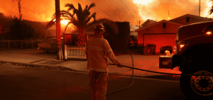 Un bombero trabaja cerca de las casas durante una tormenta de viento en Altadena, California, el 8 de enero de 2025, que alimentó feroces incendios forestales. Los incendios arrasaron la zona de Los Ángeles con una fuerza devastadora el 8 de enero, tras desencadenar una huida desesperada de los residentes de las casas en llamas a través de el fuego, vientos feroces e imponentes nubes de humo. (Foto OSV News/David Swanson, Reuters)