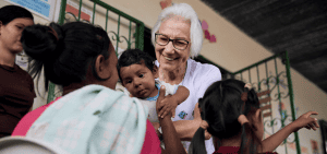La hermana scalabriniana Rosita Milesi sostiene a un bebé con su madre en la Casa de Acolhida Sao Jose, un refugio temporal para refugiados y migrantes en Pacaraima, Brasil, el 24 de agosto de 2024. La administración Trump canceló los planes de viaje para refugiados previamente aprobados bajo el programa de reasentamiento del gobierno estadounidense. (ACNUR/Marina Calderon/Folleto vía Reuters)