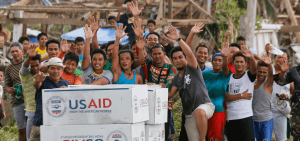 Imagen destacada: En esta foto del 2013, un grupo de filipinos demuestra su gratitud al personal de un avión de la marina estadounidense tras recibir asistencia humanitaria de la Agencia de los Estados Unidos para el Desarrollo Internacional en la remota aldea de Guiuan, Filipinas, después del paso de uno de los tifones más fuertes en récord. El futuro de USAID (Agencia de los Estados Unidos para el Desarrollo Internacional) está en tela de juicio después de que reportes dijeran que el presidente Donald Trump ha decidido "cerrar" la agencia, lo que tendría impactos severos en los pobres y los grupos que les brindan ayuda. (OSV News/Wolfgang Rattay, Reuters)