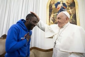 Imagen destacada: El Papa Francisco bendice a Mbengue Nyimbilo Crepin, un migrante de Camerún cuya esposa e hija murieron en julio cruzando el desierto del norte de África, durante una reunión en la Domus Sanctae Marthae en el Vaticano el 17 de noviembre de 2023. (Foto CNS/Vatican Media)