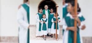 El Padre Maryknoll William Senger posa con las monaguillas después de la Misa en una de las doce capillas construidas por los Padres y Hermanos Maryknoll en Petén, Guatemala. (Octavio Durán, OFM/Guatemala)