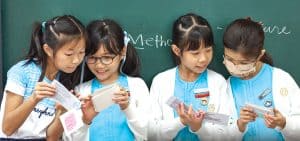 Estudiantes de la escuela primaria se preparan para dar una presentación en la clase de inglés para ser evaluadas en destrezas verbales como pronunciación, proyección vocal y confianza. (Paul Jeffrey/Hong Kong)