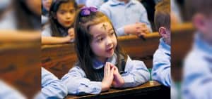 Una estudiante de kindergarten reza durante la Misa del Miércoles de Ceniza en la Iglesia Nuestra Señora de Lourdes en Malverne, Nueva York. (CNS/Gregory A. Shemitz)