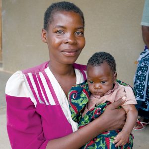 Una mamá alza a su bebé en Tanzania, donde misioneros Maryknoll sirven. (Sean Sprague/Tanzania)