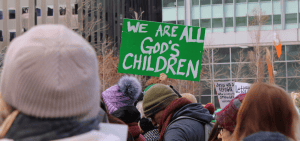 Imagen destacada: Un participante sostiene un cartel durante una manifestación interreligiosa de apoyo a los inmigrantes el 25 de enero de 2025 en Love Park, en el centro de Filadelfia. Una ley ejecutiva de Donald Trump amenaza con suspender financiación federal a ciudades santuario. (Foto OSV News/Gina Christian)