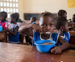 En una foto de 2017, se ve a un estudiante almorzando en una escuela primaria de la comunidad de Kumala, en el distrito de Koinadugu, en Sierra Leona. En la escuela, padres voluntarios preparan y sirven comidas calientes y nutritivas a los estudiantes todos los días a través de un proyecto de Catholic Relief Services titulado, en inglés, “Every Child Should Be Educated” (Todos los niños deben recibir educación). El proyecto forma parte de la iniciativa McGovern-Dole International Food for Education and Child Nutrition, patrocinada y financiada por el Departamento de Agricultura de los Estados Unidos. (OSV News/Michael Stulman, Catholic Relief Services)