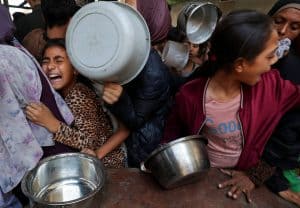Imagen destacada: Una niña palestina desplazada por la ofensiva military israelí recciona mientras espera recibir comida preparada por una organización caritativa en la ciudad de Gaza, Franja de Gaza. (OSV News photo/Mahmoud Issa, Reuters)