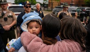 Una madre abraza a su hijo mientras varios grupos defensores de los derechos de los inmigrantes se reúnen frente a la oficina local del Departamento de Seguridad Nacional en Nashville, Tennessee, para protestar contra lo que consideran una operación conjunta de varias agencias para detener durante la noche a personas no ciudadanas en Nashville, el 4 de mayo de 2025. (OSV News/Seth Herald, Reuters)