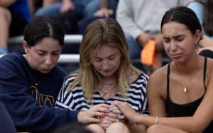 Jóvenes mujeres lloran mientras asisten a un servicio religioso en memoria de las víctimas de las inundaciones en Kerrville, Texas, el 9 de julio de 2025. Según las autoridades, a fecha de 10 de julio, más de 170 personas seguían desaparecidas y al menos 121 habían fallecido. (OSV News/Umit Bektas, Reuters)