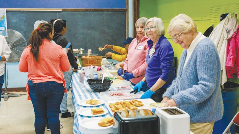 Voluntarios sirven un desayuno caliente. (Octavio Durán, OFM/EE. UU.)