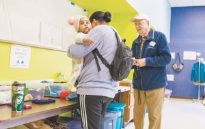 El centro ofrece servicios de asistencia, gracias a la generosidad de sus donantes y a la dedicación de sus voluntarios, como Gary Jacobs que ayuda a una madre e hijo a seleccionar ropa. (Octavio Durán, OFM/EE. UU.)
