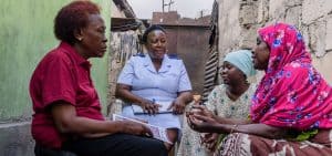 Imagen destacada: Hadija, una trabajadora de la salud, y Upendo, una enfermera, van de hogar en hogar para llevar a cabo visitas clínicas en Mozambique como parte del trabajo de PEPFAR para apoyar a huérfanos y niños vulnerables. El programa se vio afectado por recientes recortes federales. (Cortesía de USAID-PEPFAR/Mozambique)