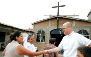 El Padre Maryknoll Joseph Everson saluda a los feligreses antes de la Misa dominical frente a la capilla de Jesús Médico en la Ciudad Juárez, donde sirvió a comunidades pobres y marginadas. (Sean Sprague/México)