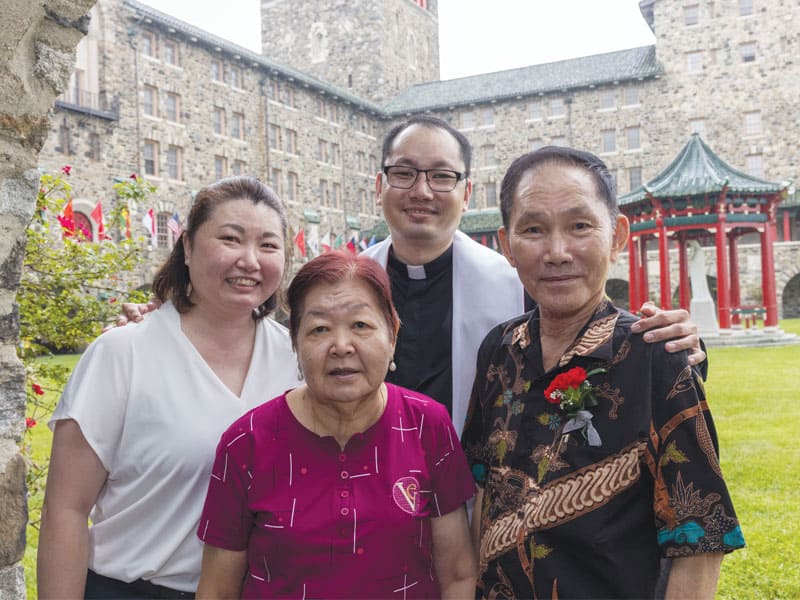 F25-Ordination-4 En el cuadrángulo de Nuestra Señora de Maryknoll, el Padre Sim comparte un momento de alegría con sus padres y su hermana, quienes viajaron desde Singapur para asistir a la ceremonia. (Octavio Durán, OFM/EE. UU.)