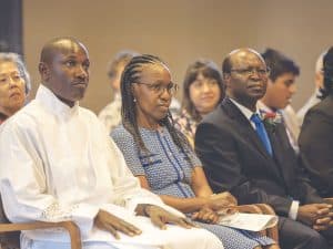 Patrick Okok, de Kenia, pidió a Florence y Jospeter Mugambi que representaran a sus padres, quienes no recibieron visas para asistir a la ordenación en Ossining, Nueva York. (Adam Mitchell/EE. UU.)