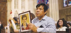 inteligencia artificial: Un feligrés que asiste a la Catedral San Patricio de Nueva York sostiene una imagen del beato Carlo Acutis, quien usó la internet para evangelizar a los jóvenes. (OSV News/Gregory A. Shemitz/EE. UU.)