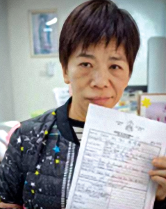 A-Mui, quien escogió Fátima como su nombre bautismal, posa para una fotografía y enseña un documento. (Cortesía de Arlene Trant/Macao)