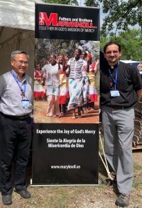 El Padre Maryknoll Rodrigo Ulloa y otro sacerdote Maryknoll posan con una pancarta que comparte el mensaje de la sociedad misionera sobre la misericordia de Dios, en una foto sin fecha. Como director de vocaciones de los Padres y Hermanos Maryknoll, el padre Ulloa acompaña a jóvenes que disciernen un compromiso de por vida con la misión como sacerdotes o hermanos. (OSV News/cortesía del padre Rodrigo Ulloa, M.M.)