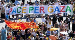 Visitantes de la Plaza de San Pedro en el Vaticano sostienen una pancarta con el lema “Paz para Gaza” mientras recitan la oración del Ángelus con el Papa León XIV el 21 de septiembre de 2025. (CNS/Vatican Media)