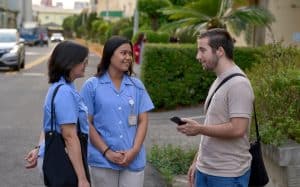 Charles Niece, director de derechos humanos y transparencia en la cadena de suministro, un proyecto de Maryknoll con sede en Taiwán, habla con los trabajadores al salir del trabajo en una fábrica de lentes para cámaras en Taichung, Taiwán. (Paul Jeffrey/Taiwán)