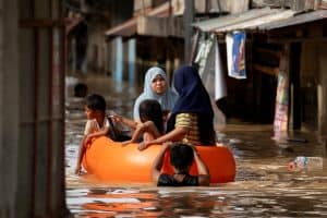 Un grupo de personas flota en un bote de rescate en una calle inundada en Nueva Ecija, Filipinas, el 18 de noviembre del 2024, después de que el tifón Man-yi. Man-yi dejara un saldo de por lo menos siete muertos tras un derrumbe, viviendas destruidas y causara el desplazamiento de un gran número de damnificados antes de su paso por el norte de las Filipinas, lo que recrudeció una crisis provocada por tormentas consecutivas, dijeron oficiales. (OSV News/Lisa Marie David, Reuters)
