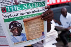 La gente lee los periódicos que informan sobre los ataques aéreos estadounidenses contra los militantes del Estado Islámico en Nigeria, según el presidente de los Estados Unidos, Donald Trump, y el ejército estadounidense, en Lagos, Nigeria, el 26 de diciembre de 2025. Mientras que algunos líderes de la Iglesia católica nigeriana acogieron con satisfacción los ataques aéreos estadounidenses contra los militantes del grupo Estado Islámico en el noroeste del país, un obispo se opuso firmemente a ellos, y algunos líderes eclesiásticos cuestionaron el marco religioso que subyace a la acción. (OSV News/Sodiq Adelakun, Reuters)