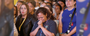Una mujer reza durante la ceremonia de canonización en el Vaticano del beato José Gregorio Hernández, conocido como el «Doctor de los Pobres», y de la beata María Carmen Elena Rendiles Martínez, mientras se proyecta en una gran pantalla en la plaza La Candelaria de Caracas, Venezuela, el 19 de octubre de 2025. En el Vaticano, el papa León XIV canonizó a los dos venezolanos junto con otros cinco beatos. (OSV News/Leonardo Fernández Viloria, Reuters)