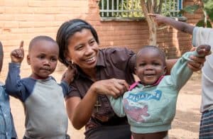 La Hermana Maryknoll Genie Natividad ayuda a los niños con ejercicios de sanación del trauma en la Fundación Karibu (“Bienvenida”) para niños maltratados, fundada por una mujer canadiense con el fin de ayudar a poner fin al maltrato infantil. (Nile Sprague/Tanzania)