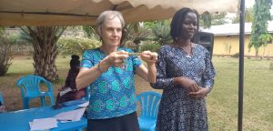 La Misionera Laica Maryknoll Joanne Blaney (izquierda) imparte un curso sobre superación del trauma y resolución no violenta de conflictos en el norte de Uganda. Immaculate Adong (derecha), que tenía 8 años cuando su padre fue asesinado en la masacre de Atiak en 1995, ahora dirige una cooperativa de mujeres y cría a sus cinco hijos.