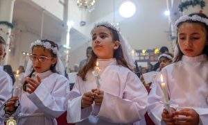 Imagen destacada: Unas niñas sostienen velas mientras el cardenal Pierbattista Pizzaballa, patriarca latino de Jerusalén, concelebra la misa en la iglesia de la Sagrada Familia, en la ciudad de Gaza, el 21 de diciembre de 2025, durante su visita pastoral navideña. El cardenal visitó antes de Navidad como muestra de cercanía hacia una comunidad que ha soportado dos años de guerra. (OSV News/cortesía del Patriarcado Latino de Jerusalén)
