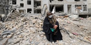 Una mujer se sienta entre los escombros frente a su apartamento destruido en Teherán, Irán, el 12 de marzo de 2026, tras un ataque aéreo en el marco de la guerra entre Estados Unidos, Israel e Irán. (OSV News/Alaa Al Marjani, Reuters)