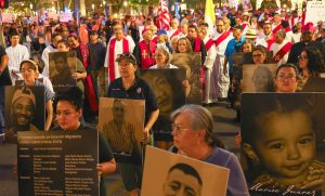 Imagen destacada: Católicos y otros manifestantes sostienen pancartas con fotografías y nombres de personas que fallecieron en circunstancias relacionadas con la migración, mientras participan en una protesta en El Paso, Texas, el 24 de marzo de 2026, en contra de las deportaciones masivas y las políticas migratorias de la administración Trump. Se puede ver al obispo Mark J. Seitz de El Paso --situado al centro y portando un solideo episcopal-- participando en la protesta. (Foto OSV News/José Luis González)