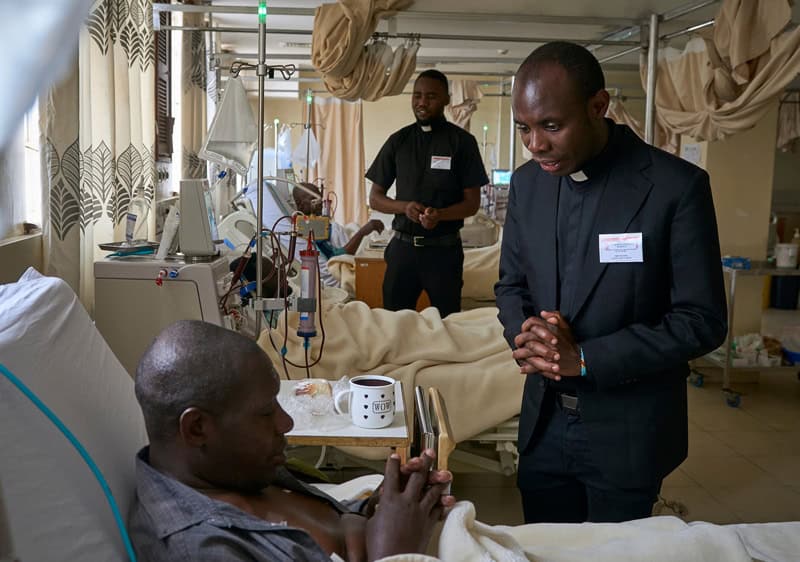 Para su experiencia pastoral, los candidatos Frederick Richard Luhende (izq.) y Babluu Ekama Kyamba (dcha.) visitan a pacientes en el hospital St. Francis Community en Nairobi, Kenia. (Paul Jeffrey/Tanzania)