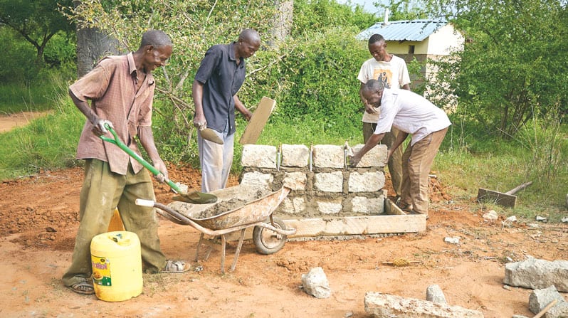 Unos trabajadores dan los últimos retoques a un pozo de abastecimiento de agua en la<br />
iglesia de San Miguel Arcángel, en Kamboo, donde los Padres y Hermanos Maryknoll ayudan<br />
a transformar vidas. La zona de Kibwezi ha sido devastada por el cambio climático. (Paul Jeffrey/Kenia)