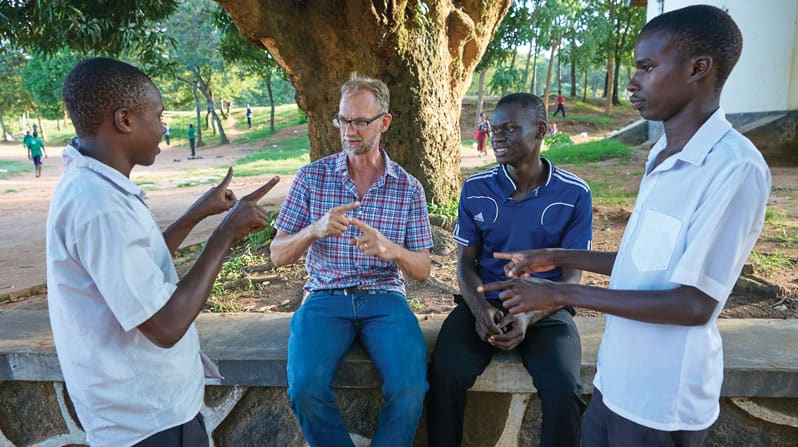 Stephen Veryser, misionero laico Maryknoll, utiliza el lenguaje de señas para impartir clases<br />
particulares de matemáticas a estudiantes sordos en la Escuela Técnica para Varones Bwiru,<br />
donde prestó servicio anteriormente con la organización internacional Cuerpo de Paz. (Paul Jeffrey/Tanzania)