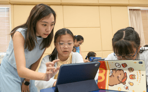 Una docente de la clase de música digital ayuda a estudiantes a crear loops en el género musical de su preferencia usando Garageband en iPads. (Paul Jeffrey/Hong Kong)