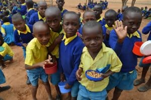 Imagen destacada: Estudiantes disfrutan una comida saludable el la escuela primara King’utheni en la área afectada por la sequía en Kibwezi, al sur de Kenia, donde misioneros Maryknoll patrocinan varios proyectos.(Moses Njagua Gitahi/Kenya)